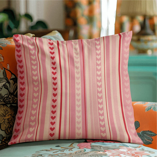 These cute cozy throw pillows for couch have a fun and cheery hearts and stripes pattern in red, pink, and peach for a fun girly apartment vibe.