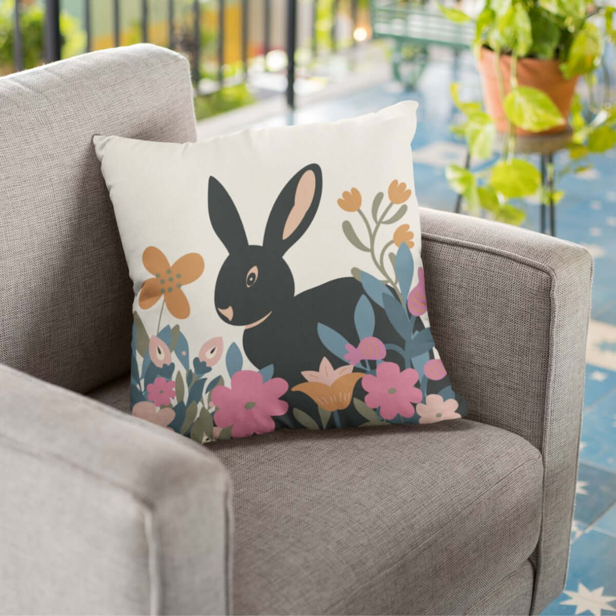 The garden bunny throw pillow in a chair on a patio