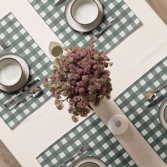 The green color option Conni cloth placemat set is shown as a table setting on a table cloth with flowers.