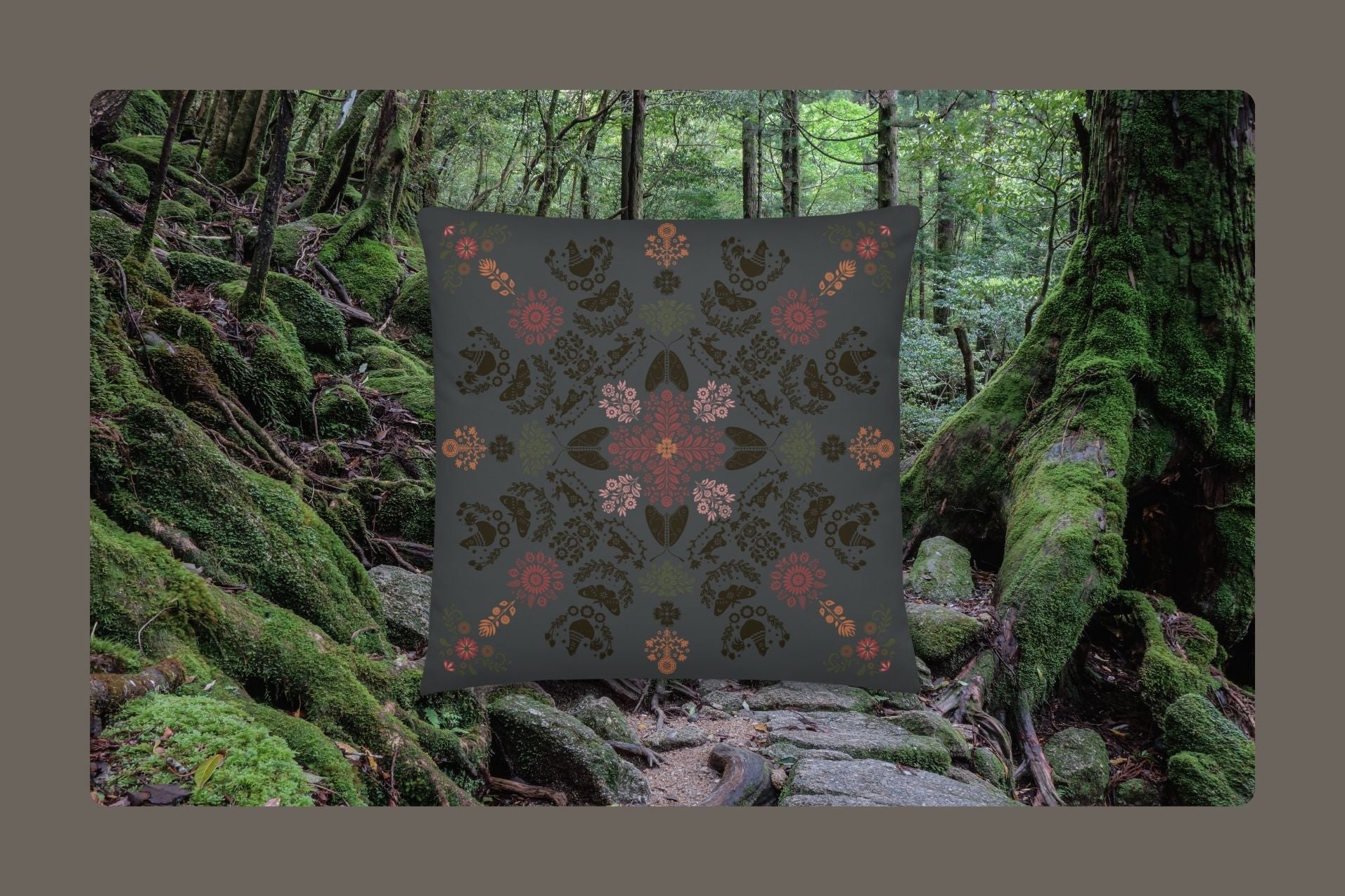 The Angela dark whimsy pillow in a forrest that's covered in mosses and stones.
