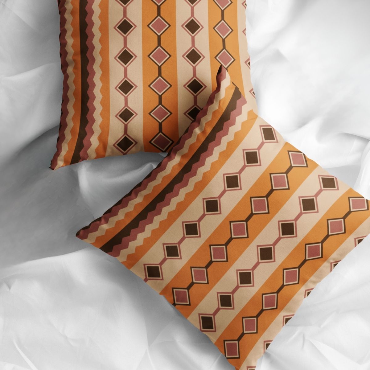 Two Gwin modern boho pillows shown side-by-side on a white bed.