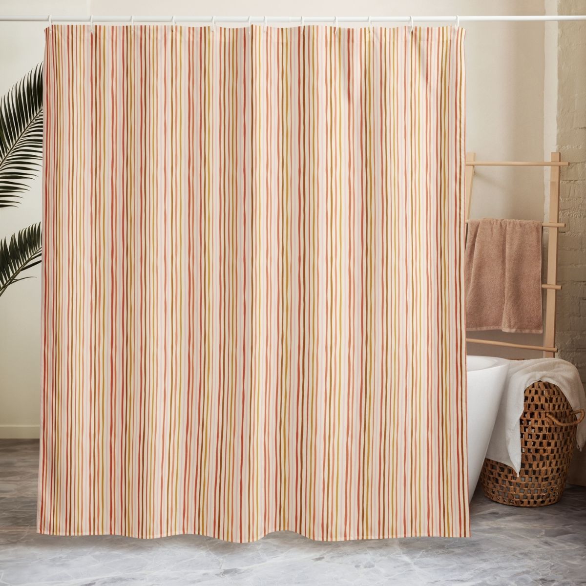 Striped shower curtain in a bathroom setting with a towel rack and basket.