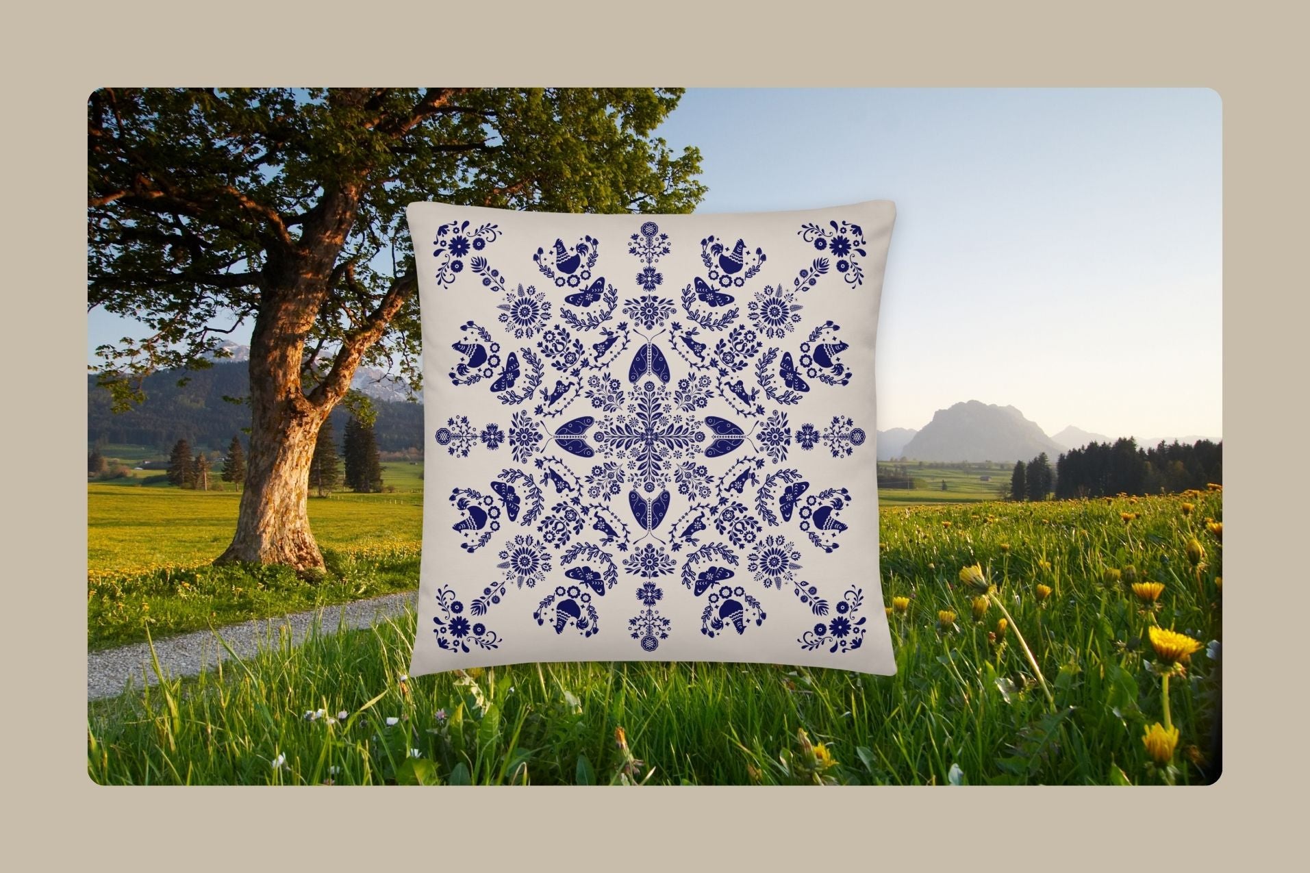 The Maria whimsy pillow in a field of flowers and mountains in the background.