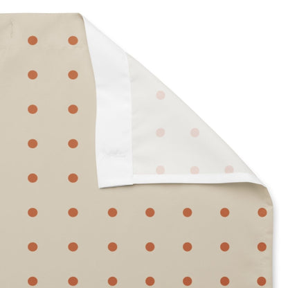 Fabric swatch with polka dot patterns on a beige background and white backside