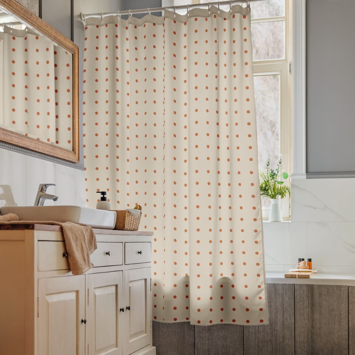 Bathroom with a polka dot shower curtain, sink, and mirror.