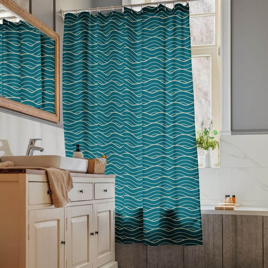The Oliver rich aqua fabric shower curtain handing in a bathroom with wood and marble tile.