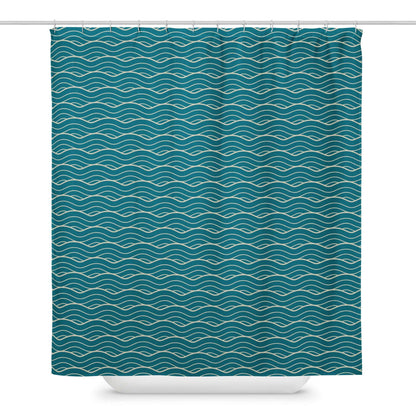 The Oliver geometric ocean waves shower curtain hanging from a shower bar in front of a bathtub.