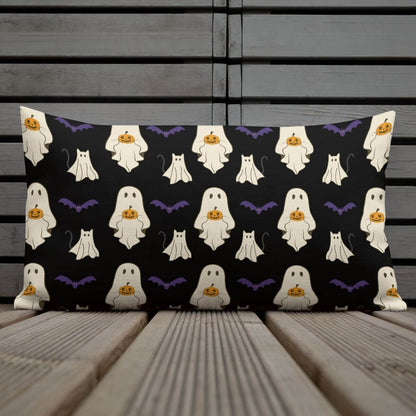 Halloween-themed pillow with ghost and pumpkin pattern on a wooden surface
