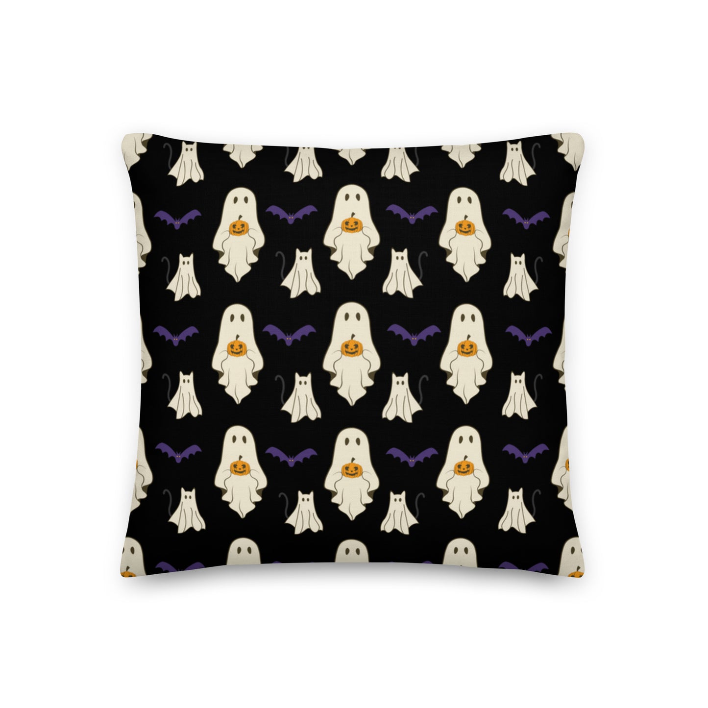 Halloween pillow with ghosts, cats, bats, and pumpkins against a black background.