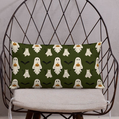 Halloween-themed pillow with ghost and pumpkin pattern on a decorative chair.