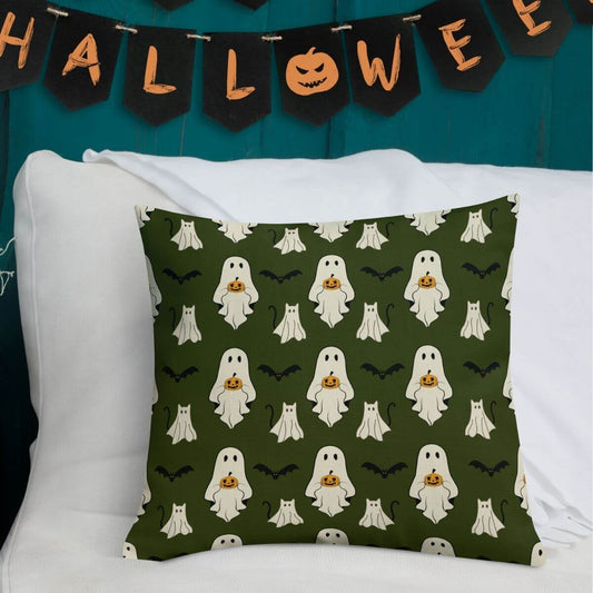 Halloween-themed pillow with ghost pattern on a white couch against a teal wall with 'Halloween' banner.