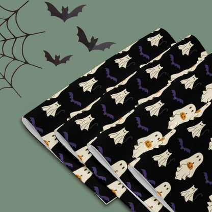 Halloween-themed placemats with a ghost and bat pattern on a black background