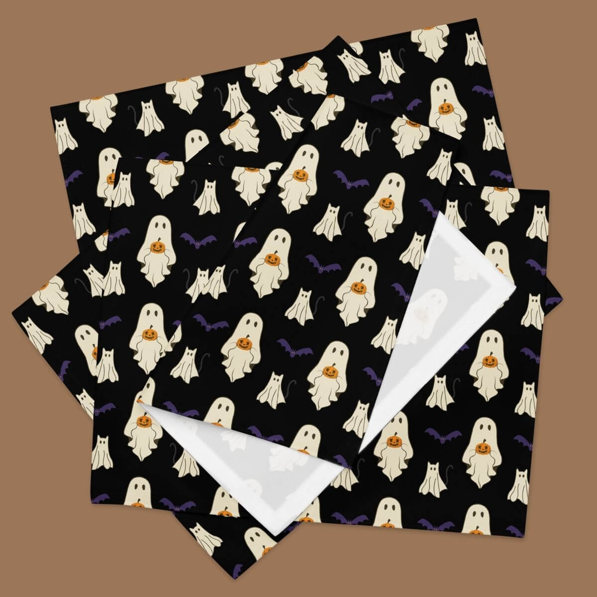 Halloween-themed placemats with ghost pattern on a brown background