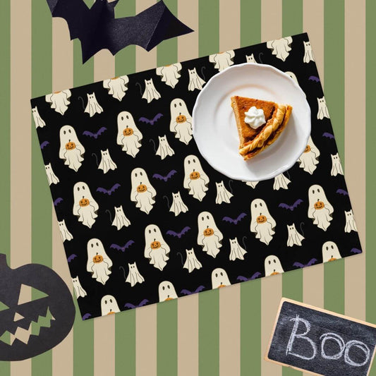 Halloween-themed placemat with ghost pattern, slice of pie on a plate, and 'BOO' sign.