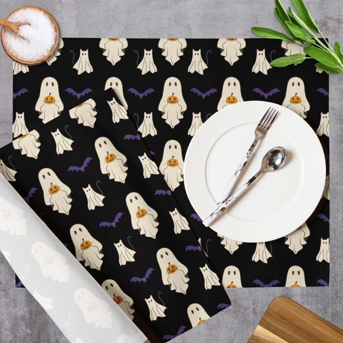 Halloween-themed placemat with ghost pattern on a table setting.