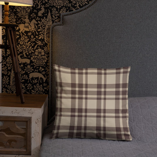 The Atticus pillow's plaid side is shown on a gray bed with a folk-inspired wallpaper in the background, demonstrating the versatility this pillow has to offer.