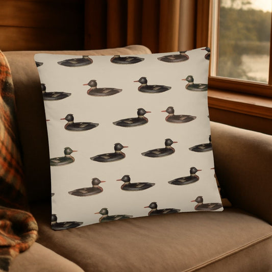The Atticus duck patterned pillow is shown on a couch by a window with a lake view, adding a playful yet cozy vibe to this log cabin. 
