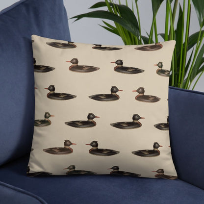 This playful, yet cozy, duck patterned pillow is shown on a modern blue couch with a plant in the background.