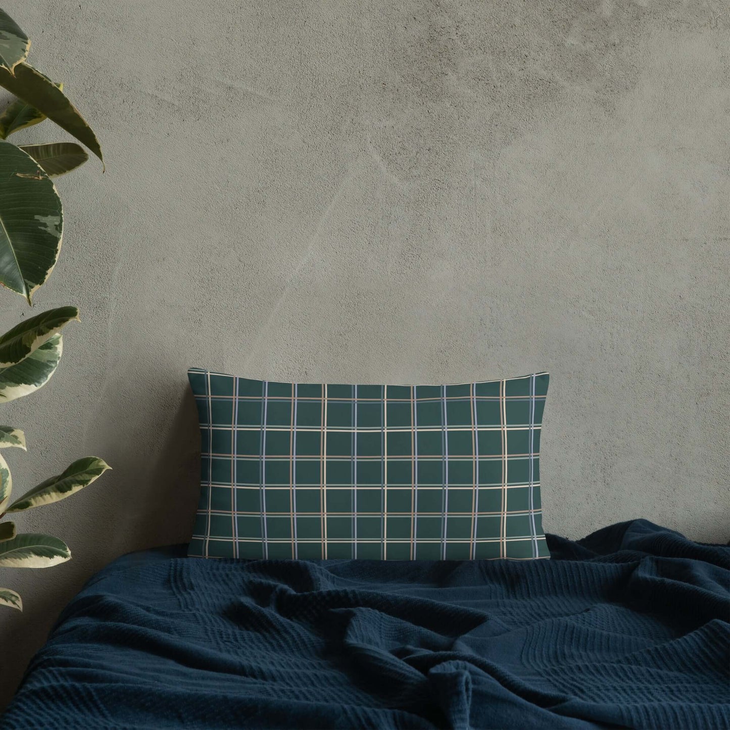 The Glen lumbar pillow adds a touch of whimsy and cozy charm to any room in the house with its pastel plaid pattern set against a dark green.