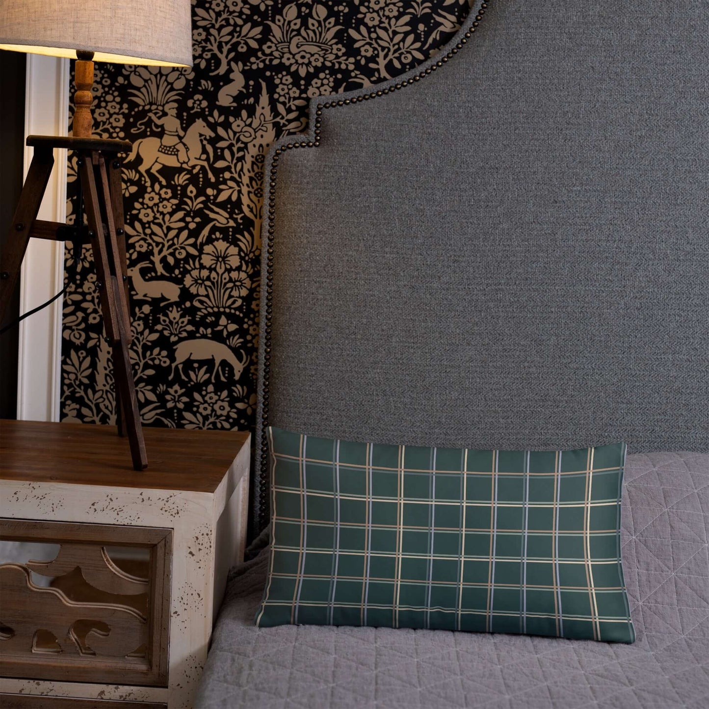 The Glen decorative lumbar throw pillow adds a cozy whimsical feel to the bedroom with its pastel plaid design against a midnight green background.