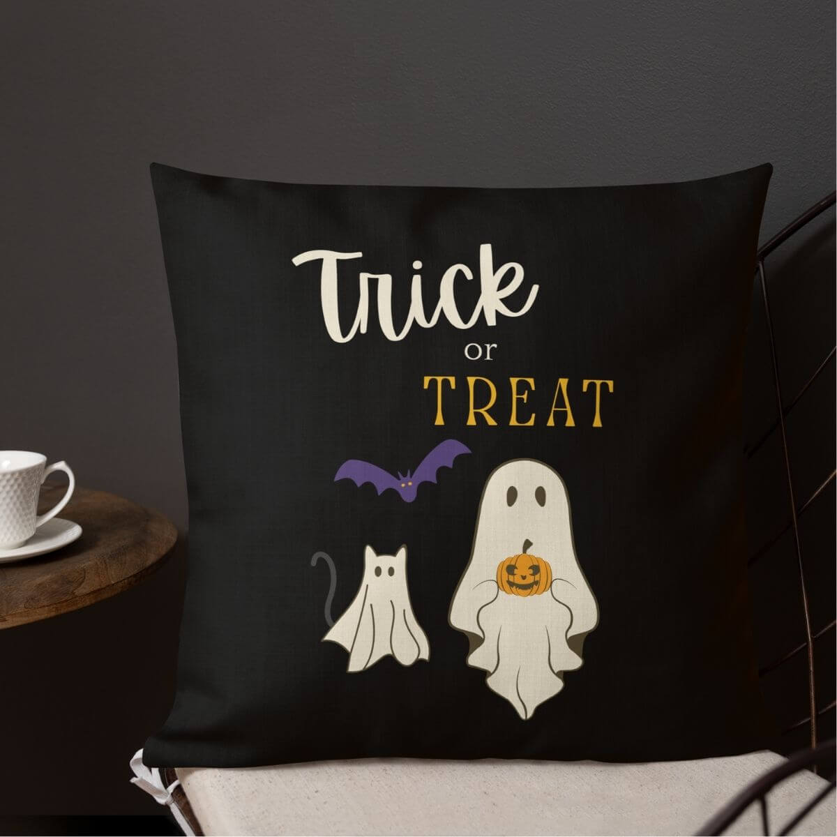 Black pillow with Halloween-themed design featuring ghosts, a bat, and 'Trick or Treat' text.