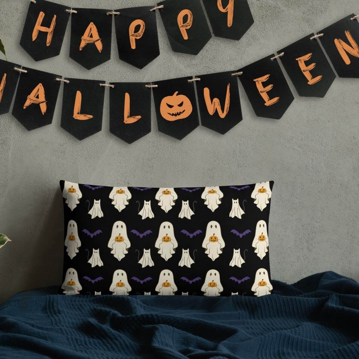 Halloween-themed pillow with ghost pattern and 'Happy Halloween' banner on a gray wall.